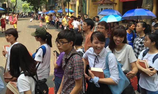 Hàng dài những bạn đọc trẻ xếp hàng dọc phố Đinh Lễ, hầu như mỗi người đều phải đợi hơn 4 tiếng đồng hồ để được xin chữ ký nhà văn Nguyễn Nhật Ánh - Ảnh: V.V.Tuân