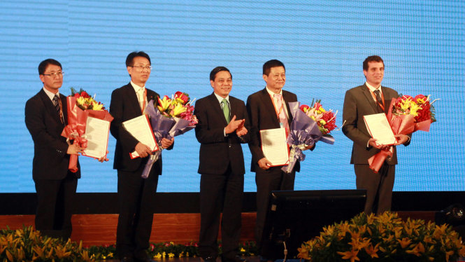 Ông Nguyễn Văn Tùng - chủ tịch UBND TP Hải Phòng (giữa) trao giấy chứng nhận đầu tư cho các nhà đầu tư trong và ngoài nước tại hội nghị xúc tiến đầu tư - Ảnh: TIẾN THẮNG