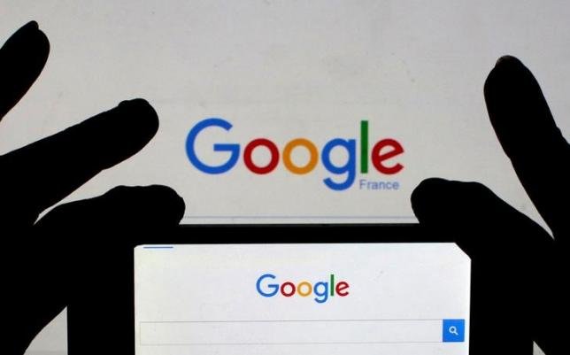 Một người phụ nữ đang cầm chiếc điện thoại thông minh của chị có hiển thị trang chủ Google trên đó - Ảnh: Reuters