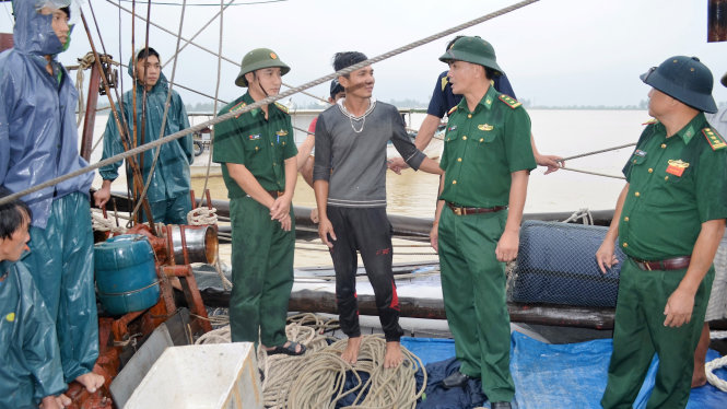 Đại diện Bộ chỉ huy BĐBP Nghệ An và Hải đội 2 thăm hỏi các ngư dân bị nạn trên tàu anh Đông - Ảnh: HÙNG PHONG