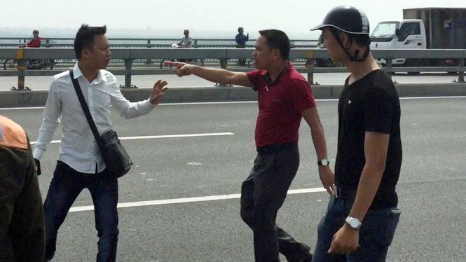 Nhà báo Quang Thế (áo trắng) bị hành hung khi đang tác nghiệp trên cầu Nhật Tân - Ảnh - M.C.