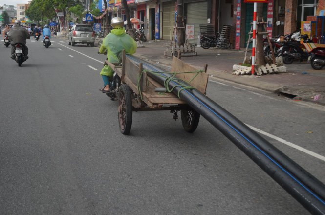 Chở ống nước lòng thòng trên đường phố Đà Nẵng - Ảnh: Quang Lực