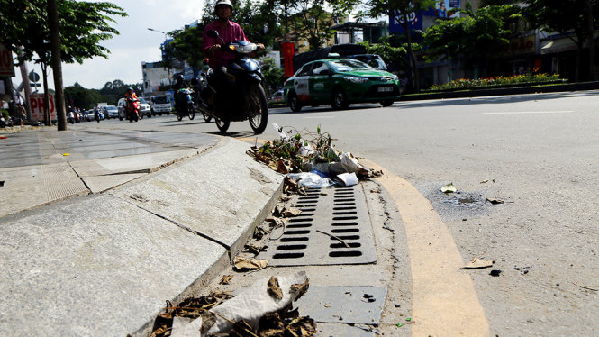 Rác ngổn ngang trên miệng cống thoát ở đường Trường Sơn (Q. Tân Bình) - Ảnh: NGỌC DƯƠNG