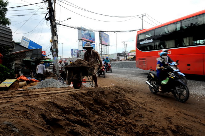 Nhà dân và dự án đường Kinh Dương Vương cùng thi công làm mặt đường lồi lõm, trơn trượt gây rất dễ xảy ra tai nạn giao thông - Ành: TỰ TRUNG