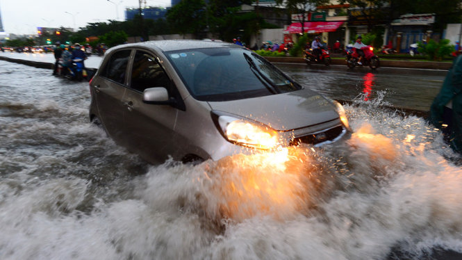 Một ôtô chạy nhanh gây sóng lớn trên đường Nguyễn Hữu Cảnh, Q. Bình Thạnh, TP.HCM do ngập sâu sau cơn mưa chiều 28-9 - Ảnh: QUANG ĐỊNH