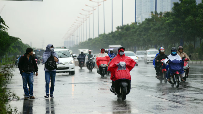 Sinh viên vất vả đội mưa đi đón xe buýt - Ảnh: Duyên Phan