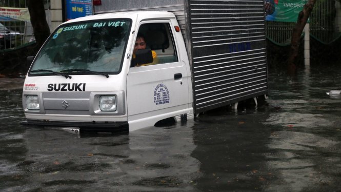 Một chiếc ô tô tải chết máy giữa dòng nước, tài xế ngồi chờ xe cứu hộ (ảnh chụp trên đường Đỗ Xuân Hợp, Q.9) - Ảnh: Tâm Đức