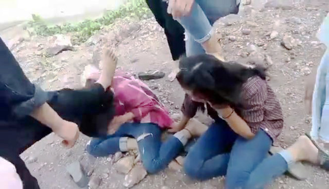 Các nữ sinh bị đánh hội đồng ôm mặt tránh đòn và không có phản kháng nào - Ảnh: D.HÒA cắt từ video clip