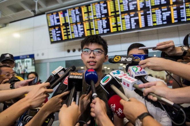 Hoàng Chi Phong trả lời phỏng vấn báo chí sau khi quay trở về sân bay quốc tế Hồng Kông - Ảnh: AFP