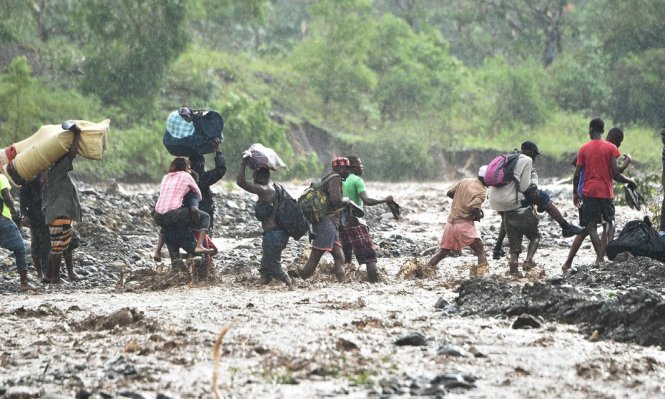 Người dân Haiti vượt sông La Digue trong mưa lớn - Ảnh: AFP
