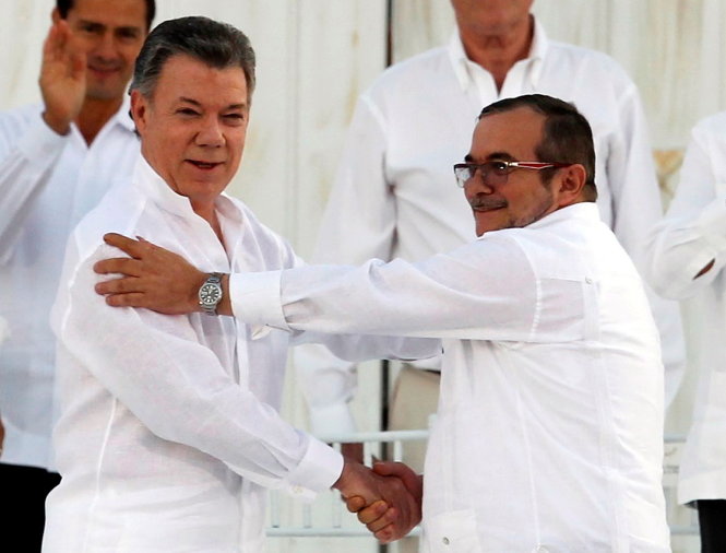 Tổng thống Colombia Juan Manuel Santos (trái) và lãnh đạo Lực lượng FARC Rodrigo Londono bắt tay nhau sau khi ký kết chính thức thỏa thuận  hòa bình tại Cartagena, Colombia ngày 26-9 - Ảnh: Reuters
