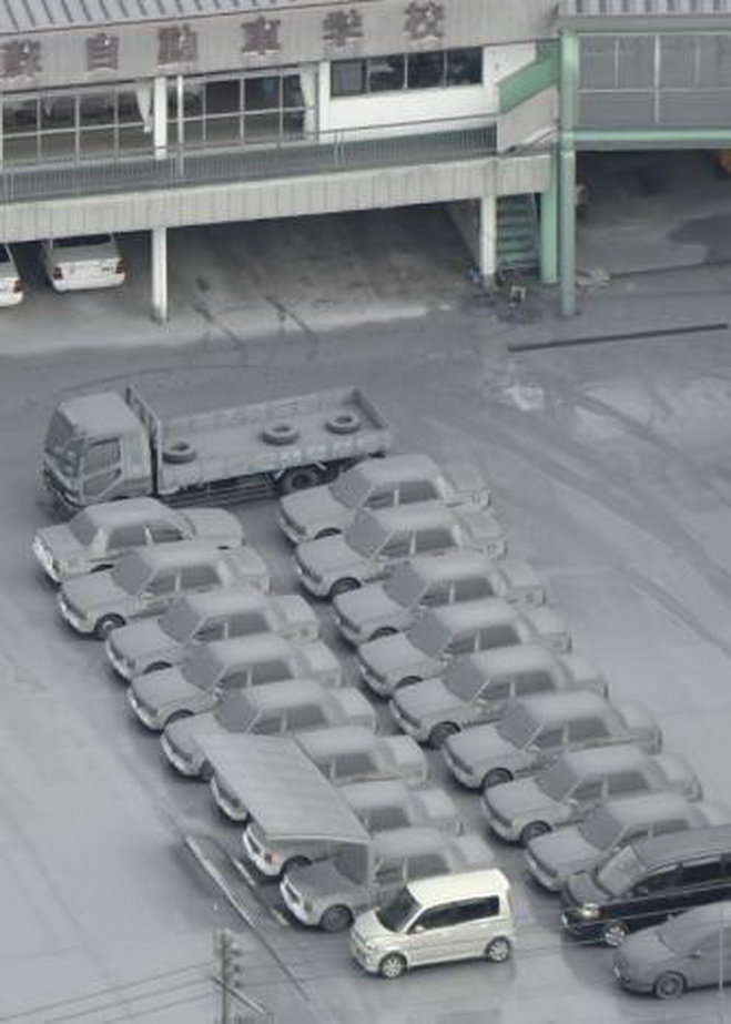 Xe ô tô ở TP Aso bị tro núi lửa che phủ - Ảnh: REUTERS