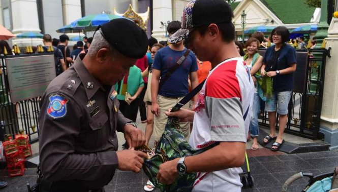 Cảnh sát Thái Lan kiểm tra túi của một du khách sau khi xảy ra vụ đánh bom đền Erawan ở Bangkok làm 20 người chết - Ảnh: AFP
