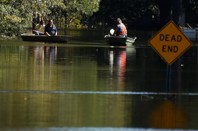 Người dân ở Lumberton, Bắc Carolina chèo thuyền đi trong nước lũ hôm 11-10 - Ảnh: REUTERS