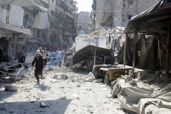 Một thành viên đội dân phòng tại một khu chợ bị không kích ở Aleppo - Ảnh: Reuters