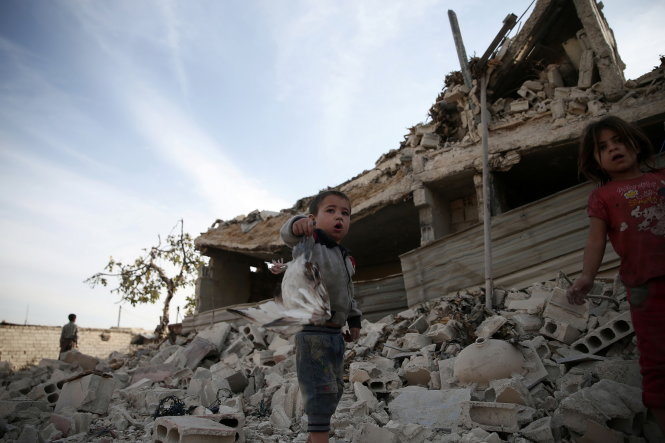 A boy shows a dead pigeon at a site hit previously by an airstrike in the rebel-held Douma neighbourhood of Damascus, Syria October 12