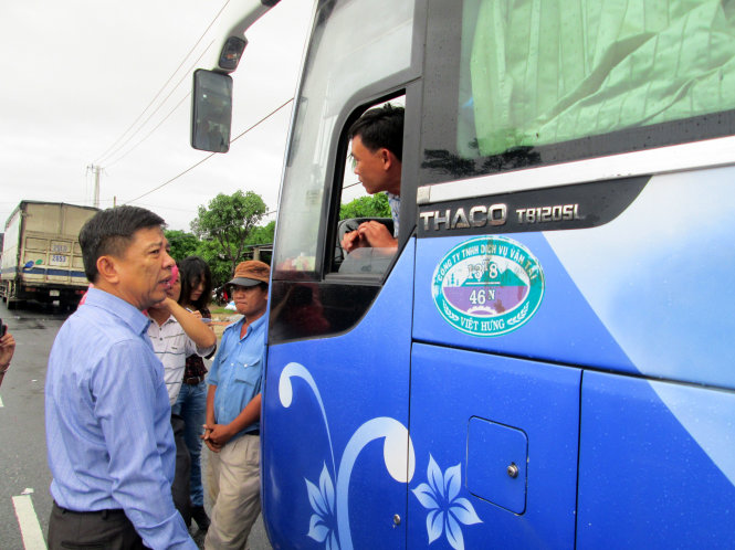 Chủ tịch UBND tỉnh Quảng Bình Nguyễn Hữu Hoài thăm hỏi lái xe Dương Ngọc Quang và hành khách trên xe đang bị kẹt đường ở đoạn bị ngập xã Đồng Trạch, huyện Bố Trạch - Ảnh: LAM GIANG