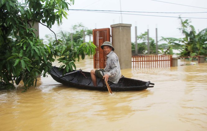 Người dân xã Cẩm Vịnh, huyện Cẩm Xuyên (Hà Tĩnh) chèo thuyền ra bên ngoài để mua lương thực, thực phẩm do nước ngập - Ảnh: DOÃN HÒA