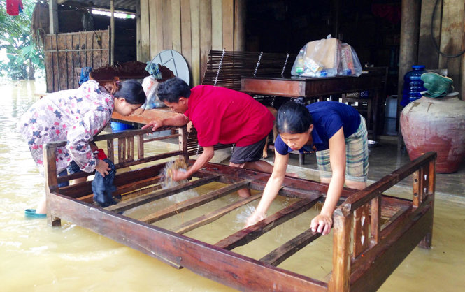 Người dân xã Hòa Hải lau dọn đồ đạc khi nước lũ rút - Ảnh: DOÃN HÒA