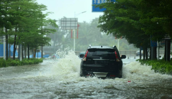 Một chiếc xe cố chạy khi đường bị ngập nặng do mưa quá lớn tại đảo Hải Nam - Ảnh: Tân Hoa Xã