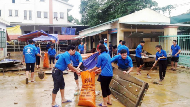 Các đoàn viên, thanh niên huyện Hương Khê giúp người dân dọn dẹp chợ Hòa Hải - Ảnh: DOÃN HÒA