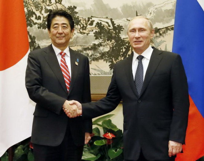 Thủ tướng Nhật Bản Shinzo Abe (trái) bắt tay với Tổng thống Nga Vladimir Putin (phải) trong một sự kiện năm 2014 - Ảnh: Reuters