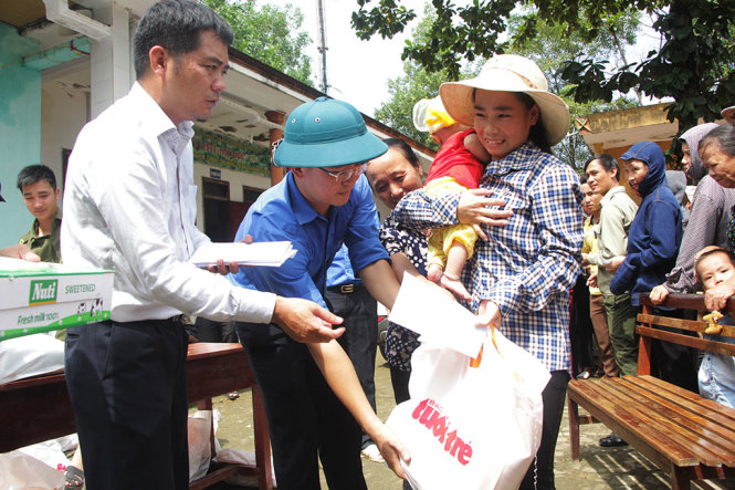 Đại diện báo Tuổi trẻ và tỉnh đoàn Hà Tĩnh trao quà cứu trợ cho người dân xã Hương Trạch, huyện Hương Khê chiều 20-10 - Ảnh: DOÃN HÒA