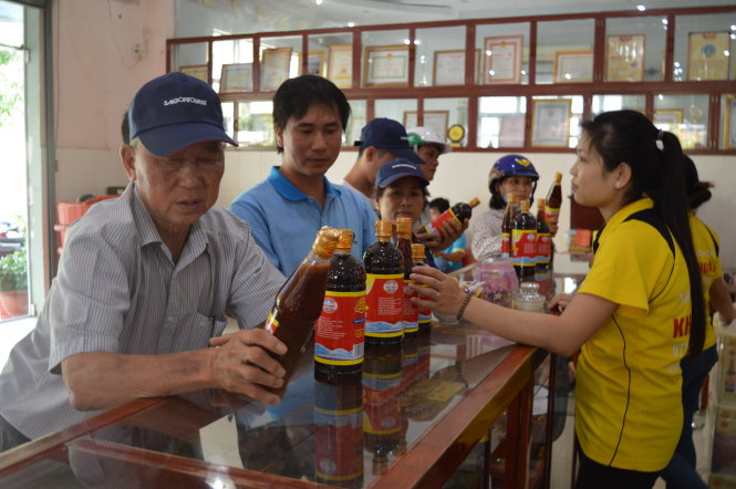 Du khách chọn mua nước mắm của cơ sở Khải Hoàn khi đến Phú Quốc du lịch - Ảnh: Hoàng Trung