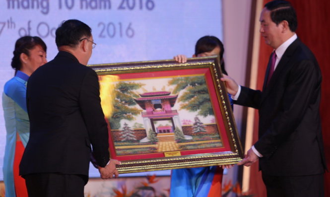 Chủ tịch nước Trần Đại Quang (phải) tặng quà lưu niệm cho Trường ĐH Kinh tế TP.HCM - Ảnh: NHƯ HÙNG