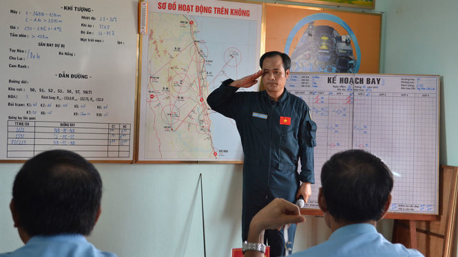 Trung tá Hoàng Xuân Kiên - chủ nhiệm chính trị Trung đoàn 925 - báo cáo tình hình thời tiết sau khi thực hiện chuyến bay trinh sát khí tượng để chỉ huy bay quyết định thực hiện kế hoạch bay - Ảnh: DUY THANH