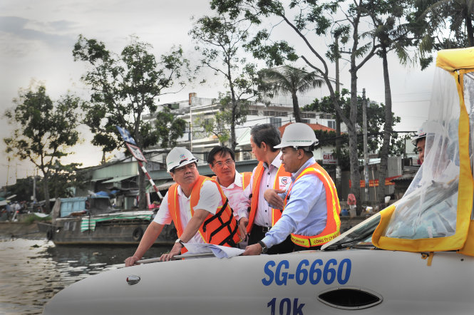 Ông Nguyễn Thành Phong (bìa trái),  chủ tịch UBND TP.HCM, kiểm tra dự án chống ngập do triều cường trên địa bàn quận 8. Đây là một trong 7 chương trình đâu tư đột phá của TP bằng nguồn vốn ngân sách - Ảnh: TỰ TRUNG