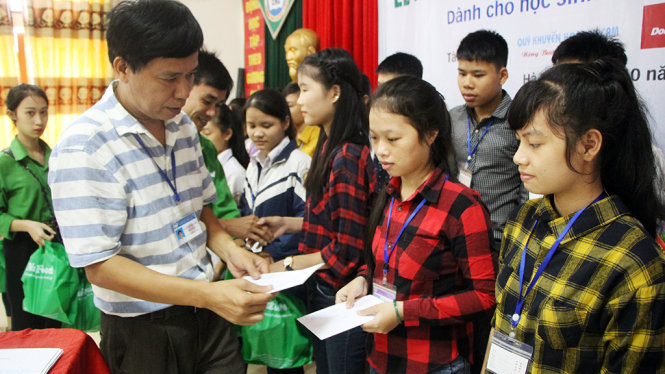 Thầy Nguyễn Hữu Toàn, hiệu trưởng Trường THPT Cù Huy Cận trao học bổng cho học sinh sáng 29-10 - Ảnh: DOÃN HÒA