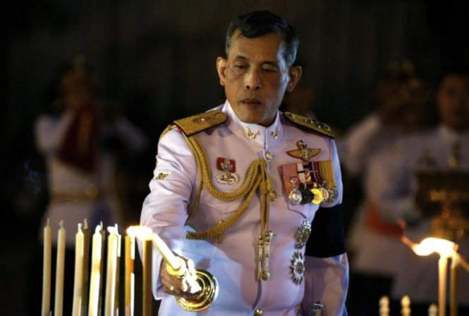 Thái tử Thái Lan Maha Vajiralongkorn thắp nến trong buổi lễ cầu nguyện cho người cha vừa qua đời, đức vua Bhumibol Adulyadej - Ảnh: Reuters