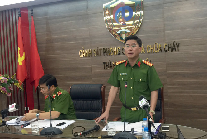 Đại tá Nguyễn Tuấn Anh, phó giám đốc Sở Cảnh sát PCCC Hà Nội (bìa phải) trao đổi thông tin về vụ cháy quán karaoke - Ảnh: THÂN HOÀNG