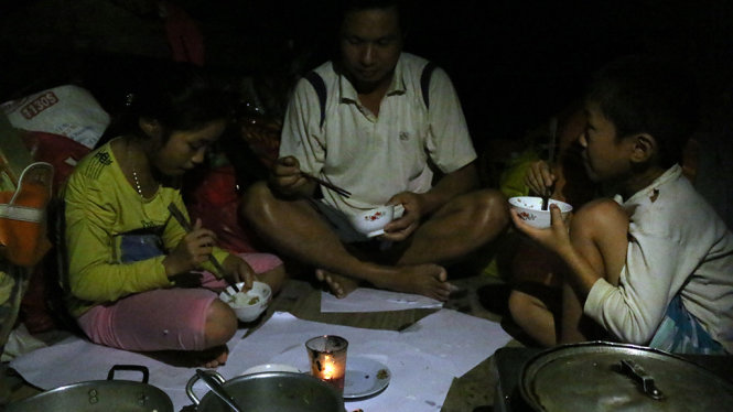 Bữa cơm muộn ngày lũ của gia đình anh Nguyễn Văn Huỳnh - Ảnh: VĂN ĐỊNH
