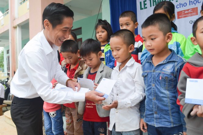 Ông Đoàn Triệu Chu Lân, công ty CP Đồng Tâm, trao học bổng cho các em - Ảnh: TẤN LỰC