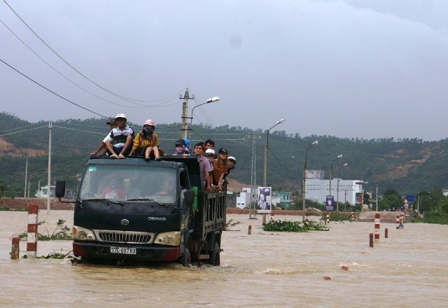 Người dân phải dùng xe trung chuyển qua đập tràn Huỳnh Mai - Ảnh: Xuân Vinh