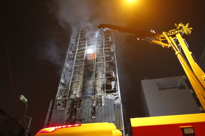 Lực lượng cứu hỏa thay phiên tiếp cận các tầng của tòa nhà để dập lửa - Ảnh: NAM TRẦN