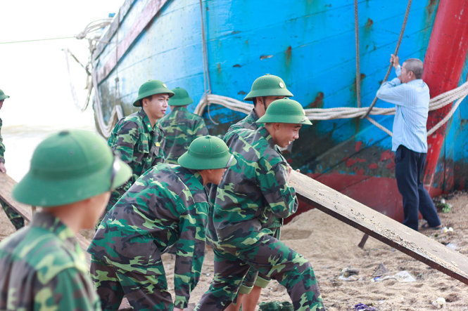 Lực lượng BĐBP tỉnh Khánh Hòa vận chuyển cây gỗ, bình ắc quy để hỗ trợ “giải cứu” tàu gặp nạn - Ảnh: THANH TRÚC