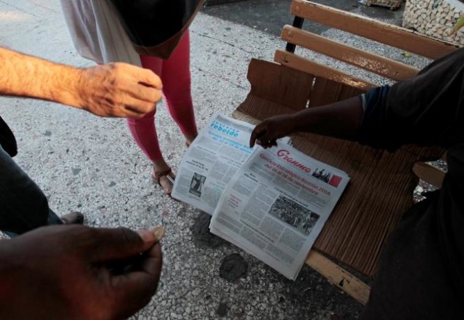 Người dân Cuba mua tờ nhật báo với dòng tiêu đề viết 