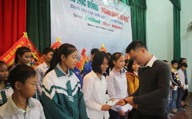 Anh Phan Trọng Lộc, trưởng ban đoàn kết tập hợp thanh niên tỉnh Đoàn Nghệ An trao học bổng cho các em học sinh THCS ở huyện Quỳnh Lưu - Ảnh: DOÃN HÒA