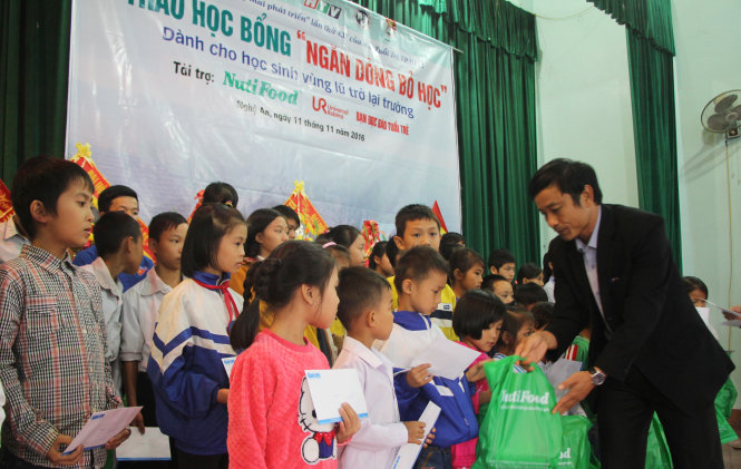Ông Thái Huy Hoàng, phó bí thư Đảng ủy, chủ tịch UBND xã Vĩnh Thành, huyện Yên Thành (Nghệ An) trao học bổng cho các em học sinh - Ảnh: DOÃN HÒA