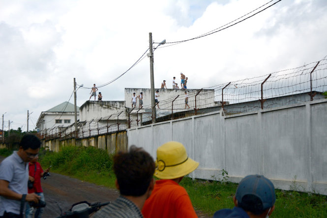 Các học viên tại Trung tâm cai nghiện tỉnh Đồng Nai hò hét, leo lên nóc nhà sáng 7-11 - Ảnh: ĐỨC TRONG
