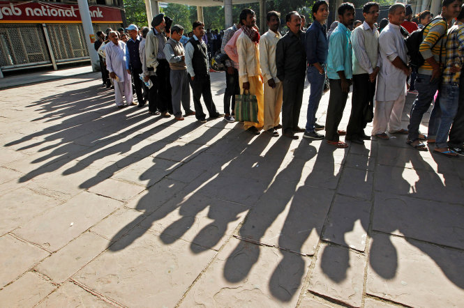 Người dân Ấn Độ xếp hàng chờ đổi tiền bên ngoài một ngân hàng ở Chandigarh - Ảnh: Reuters