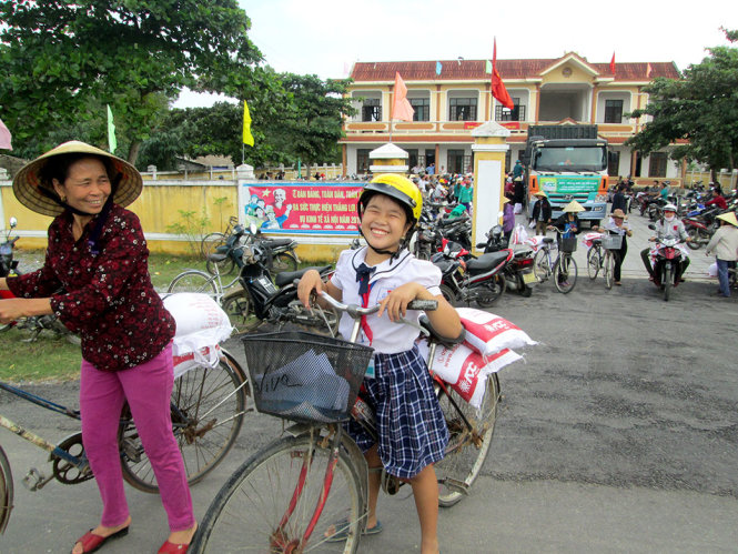 Nụ cười của Lê Thị Thuý, học sinh lớp 5C Trường tiểu học Thanh Thuỷ, khi nhận gạo cho gia đình - Ảnh L.GIANG