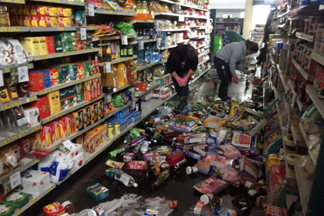Nhân viên siêu thị dọn dẹp hàng hóa bị đổ vỡ sau động đất - Ảnh: STACY SQUIRES