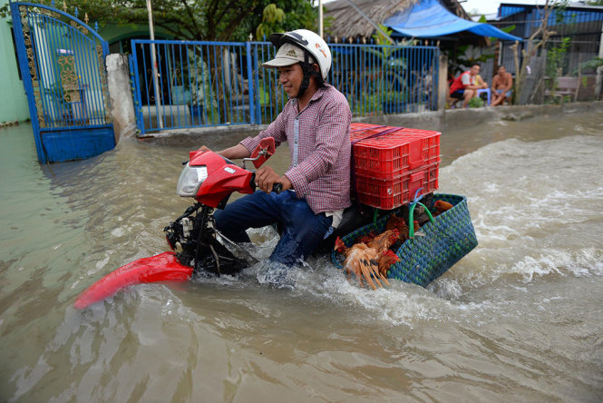 Nước ngập sâu đến yên xe trên đường Lê Văn Lương - Ảnh: HỮU KHOA