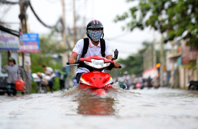 Nước ngấp sâu hết bánh xe trên đường Lê Văn Lương, Nhà Bè - Ảnh: HỮU KHOA