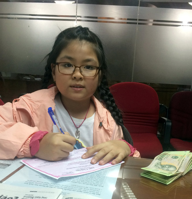 Ngày cuối tuần được nghỉ học, bé Nguyễn Ngọc Hồng Hạnh học lớp 4 Trường Mê Linh (Q.3) nhờ ba chở đến tòa soạn gửi quà cho các bạn vùng lũ - Ảnh: MKA
