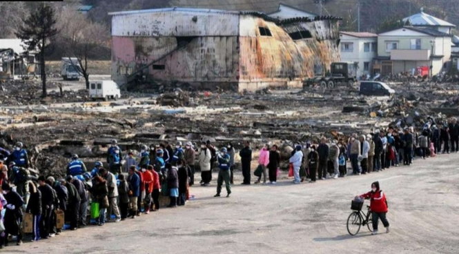 Nạn nhân động đất-sóng thần xếp hàng trật tự chờ nhận thực phẩm cứu trợ ở thành phố Yamada, Nhật Bản hôm 31-3-2011 - Ảnh: EPA